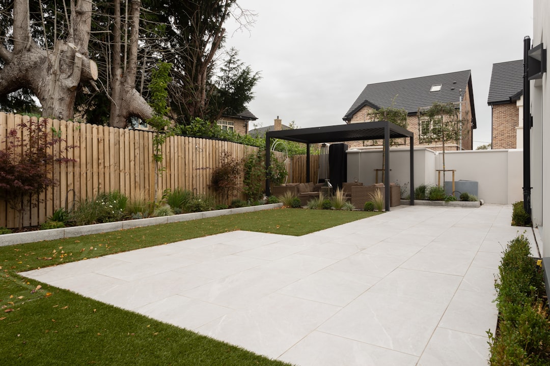 a-backyard-with-a-fence-grass-and-trees-l525hir2xei
